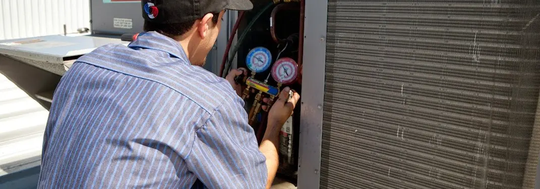 HVAC technician servicing a condenser unit in San Anselmo
